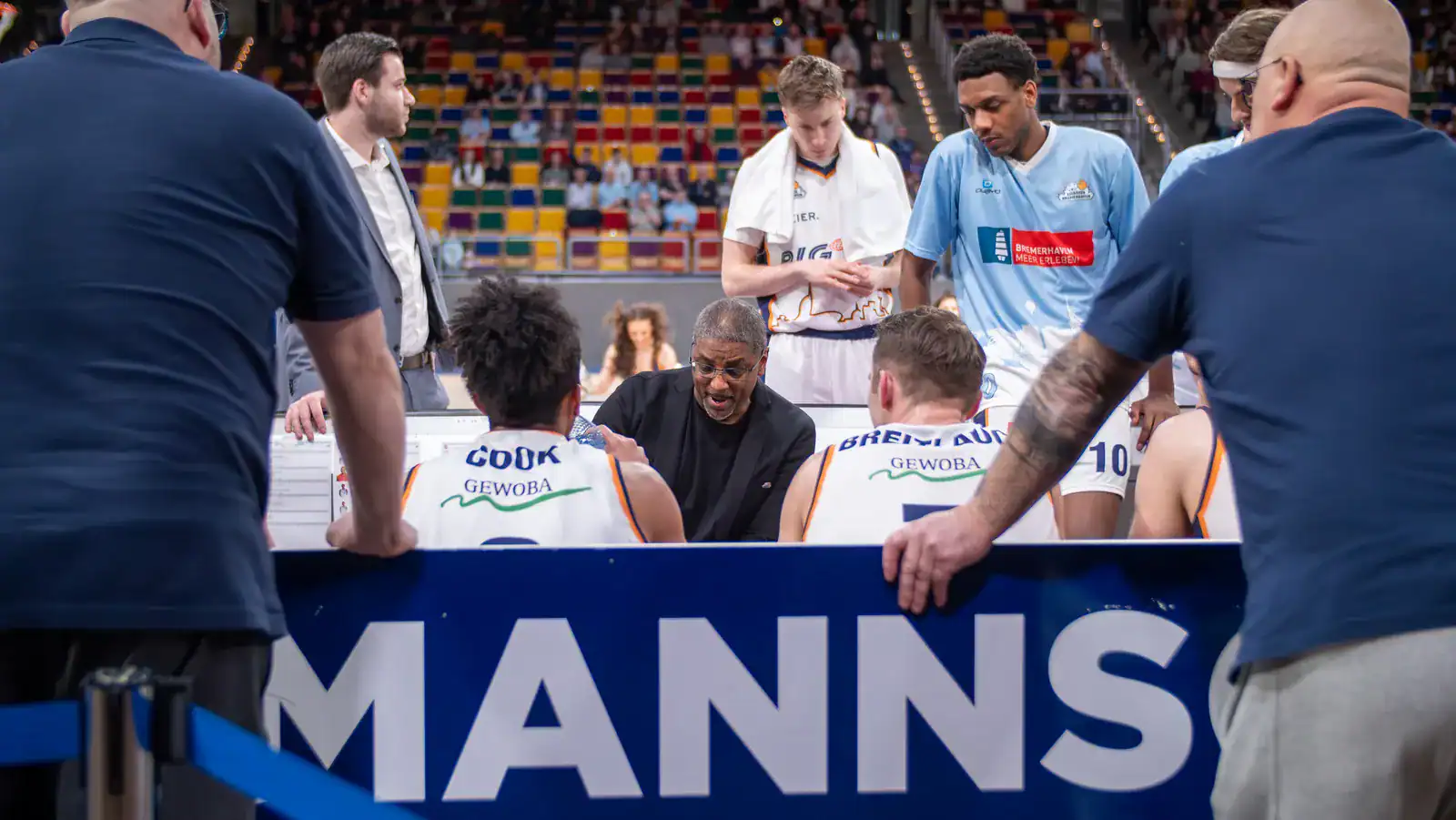 Spieler und Trainer bei einer Teambesprechung an der Mannschaftsbank.