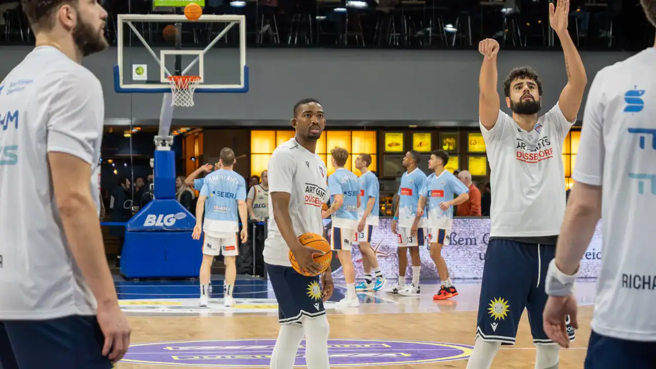 Basketballspieler beider Mannschaften beim Aufwärmen vor dem Spiel.